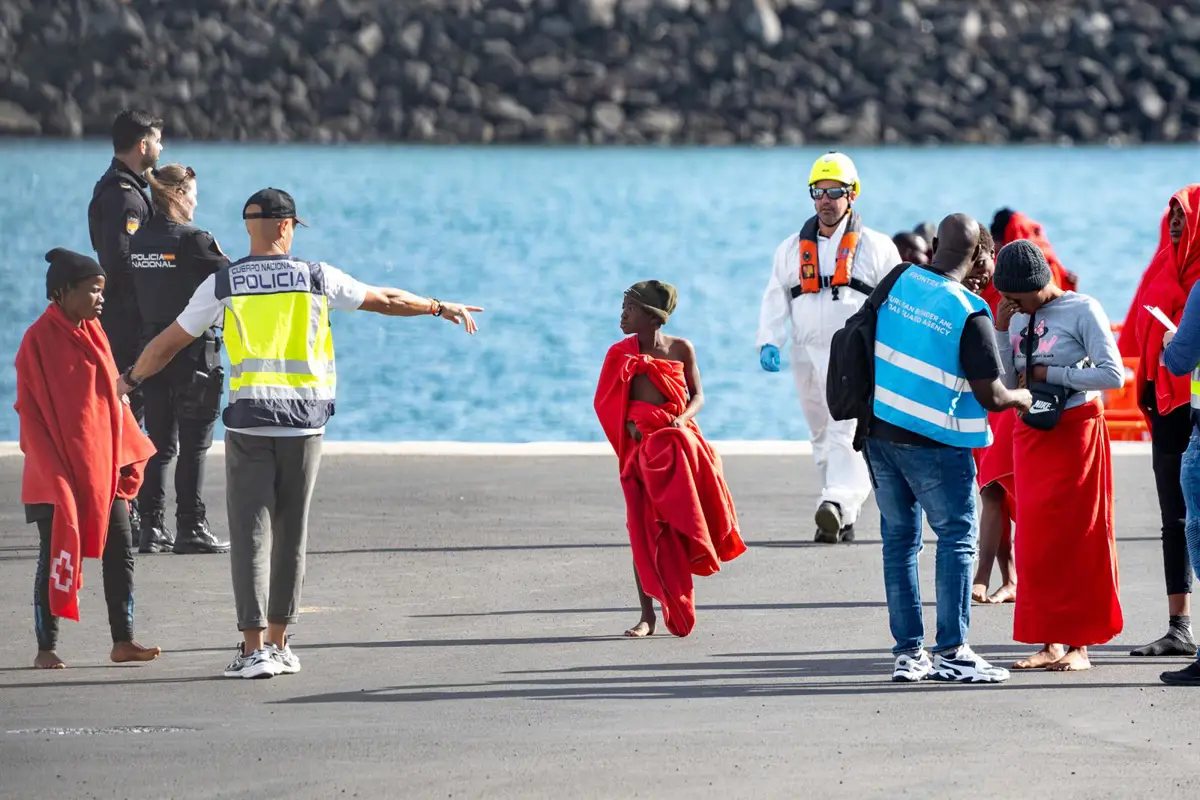 Agentes de los equipos de emergencia atienden a los migrantes en el muelle de Arrecife