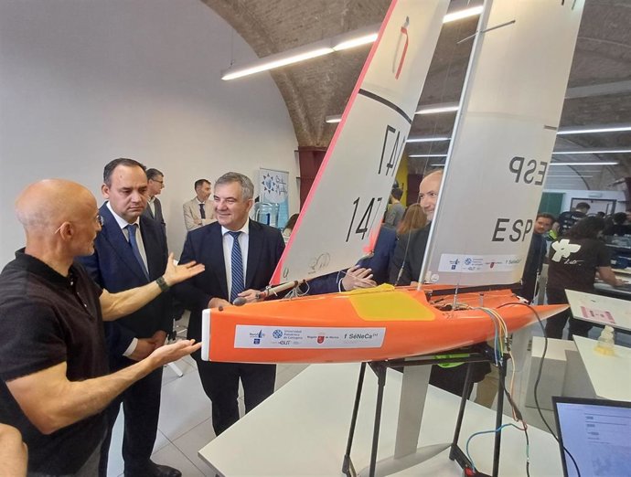 El consejero de Medio Ambiente, Universidades, Investigación y Mar Menor, Juan María Vázquez, junto al rector de la Universidad Politécnica de Cartagena (UPCT), Mathieu Kessler, junto al velero que tomará parte en la ‘Micro ruta de la sal'