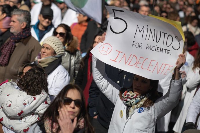Archivo - Manifestante porta pancarta con lema '5 minutos por paciente. Indecente' durante la manifestación contra el Estatuto Marco del Ministerio de Sanidad