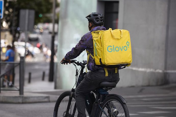 Archivo - Un repartidor de Glovo en bicicleta por una calle de Madrid 
