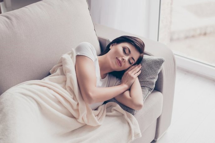 Archivo - Una joven duerme se hecha la siesta en el sofá.