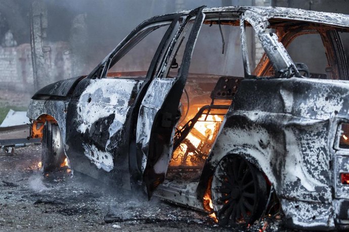 Archivo - El coche en llamas en el lugar del ataque aéreo, provocado por una bomba guiada que impactó justo al lado de una pequeña tienda de comestibles de barrio.