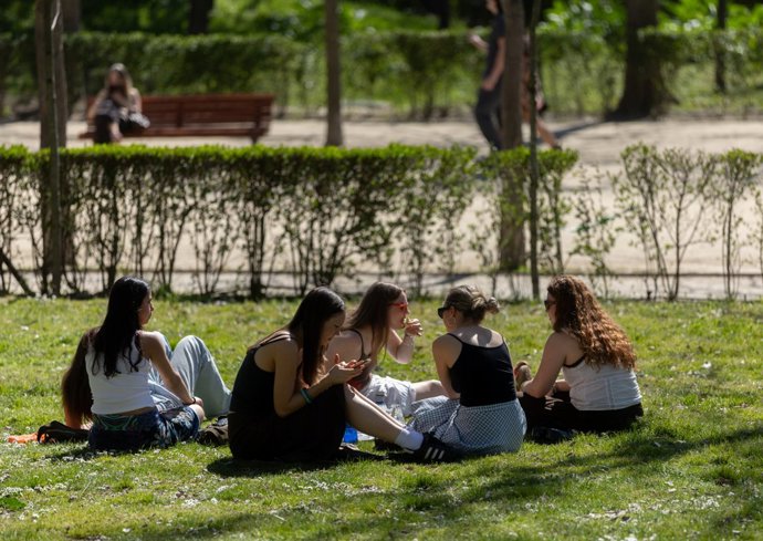 Un grupo de personas sentadas en el césped de un parque, a 17 de marzo de 2026, en Madrid (España). La primavera de 2026 --es decir, los meses de marzo, abril y mayo-- probablemente sea más cálida de lo normal en España.