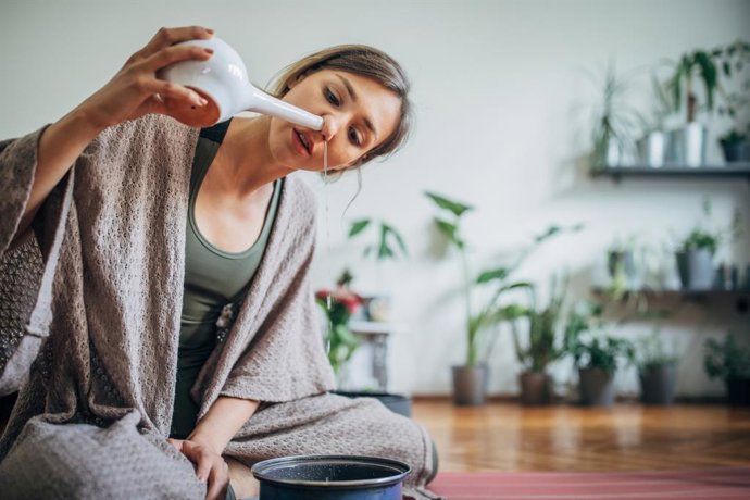 Archivo - Mujer joven usando neti pot.