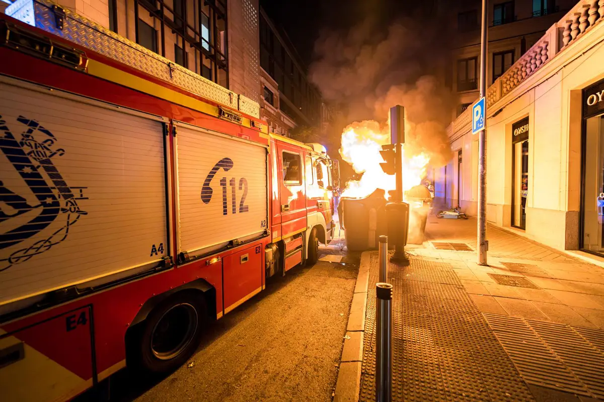 Coche de bomberos apagando un contenedor ardiendo