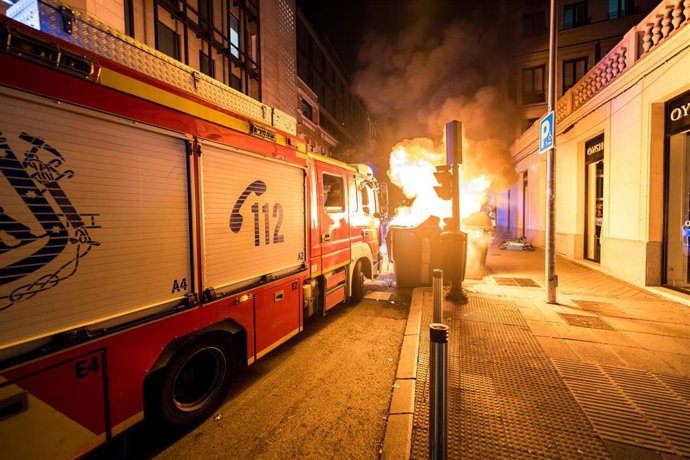 Archivo - Un coche de bomberos llega a apagar un contenedor ardiendo