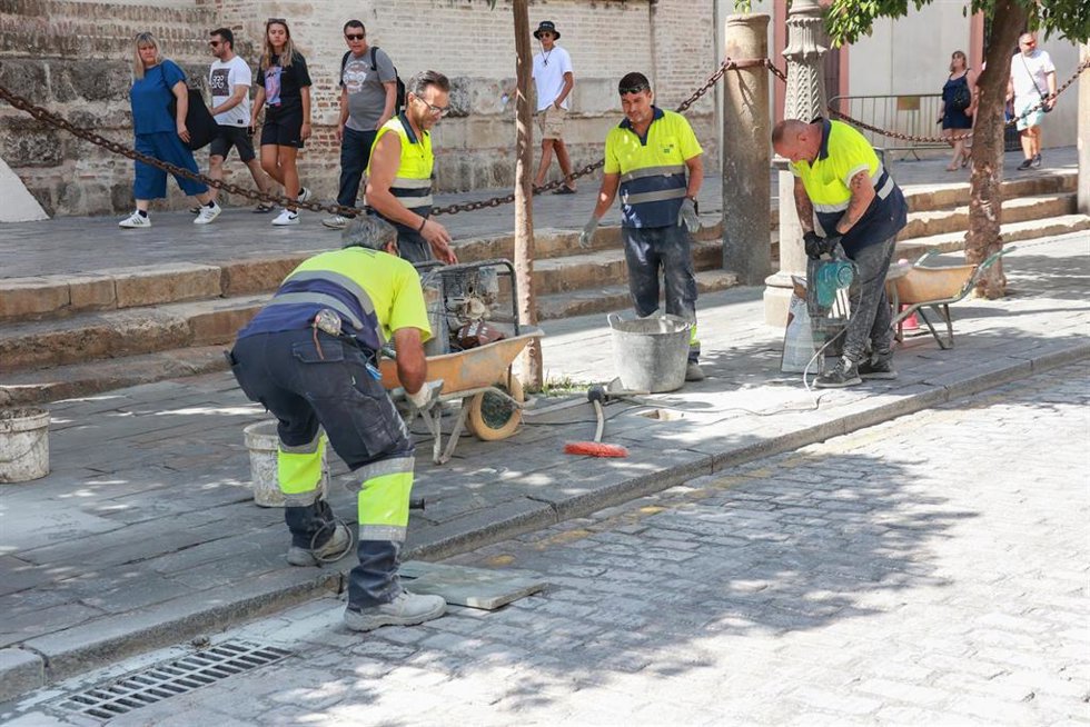 Archivo - Imagen de archivo de Varios operarios trabajan en las obras de repavimentación de la calle Alemanes, junto a la Catedral, en el centro de Sevilla. A 12 de agosto de 2024, en Sevilla (Andalucía, España).