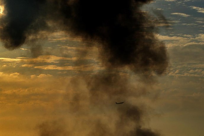 Archivo - Arquivo - 27 de abril de 2025, Líbano, Beirute: Um avião sobrevoa a densa fumaça negra que se eleva de uma área atingida por um ataque aéreo israelense no subúrbio sul de Beirute, um reduto do Hezbollah pró-iraniano. Foto: Marwan Naamani/dpa