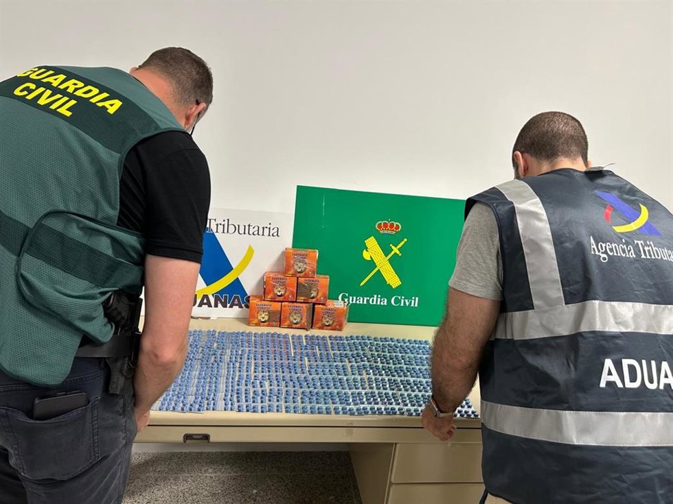 Agentes de la Guardia Civil y la Agencia Tributaria con la mercancía incautada.