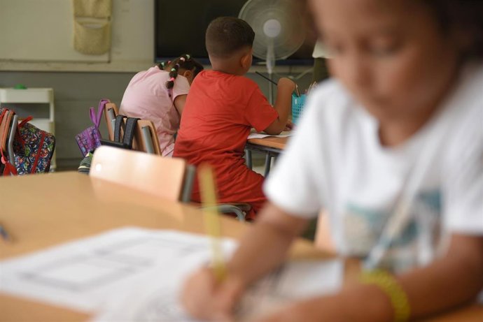 Archivo - Varios niños en una mesa de colegio 