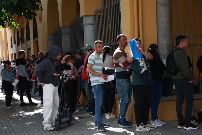 Personas migrantes hacen cola para la tramitación de su regularización administrativa en Sevilla. A 20 de abril de 2026 en Sevilla (Andalucía, España). Oficinas de Correos, de la Seguridad Social y de Extranjería comienzan este lunes 20 de abril a atender