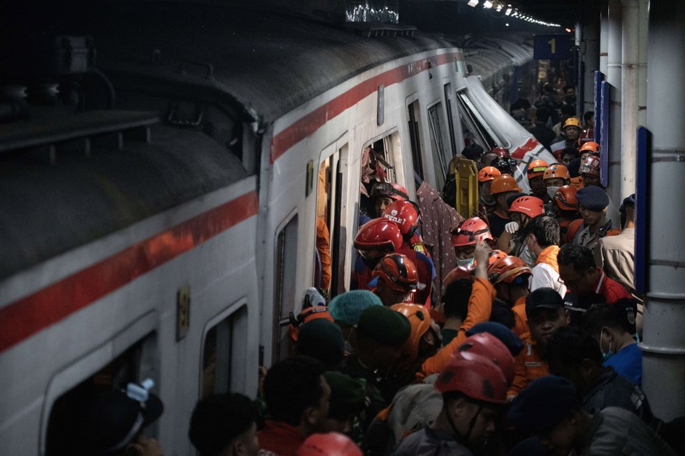 28 April 2026, Indonesia, Bekasi: people and first responders gather around a wrecked train after a collision occurred between two trains involving a Commuter Line train that was rear-ended by the Argo Bromo, a long-distance train bound for Java.