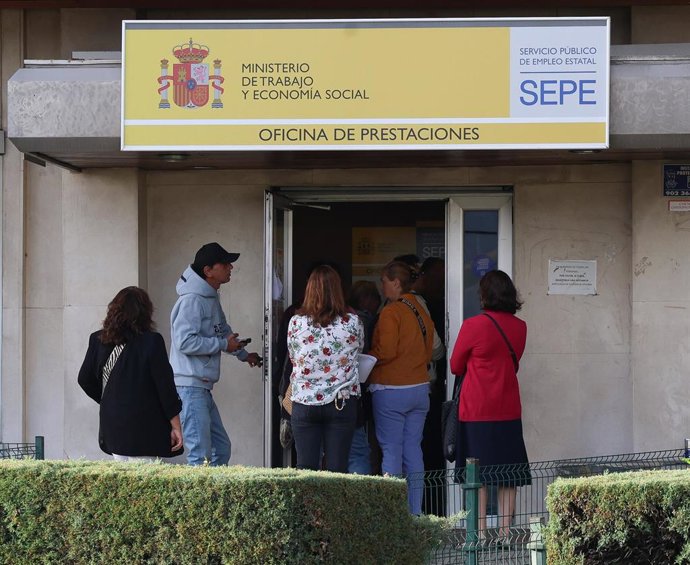 Archivo - Varias personas en la entrada de una oficina del SEPE.