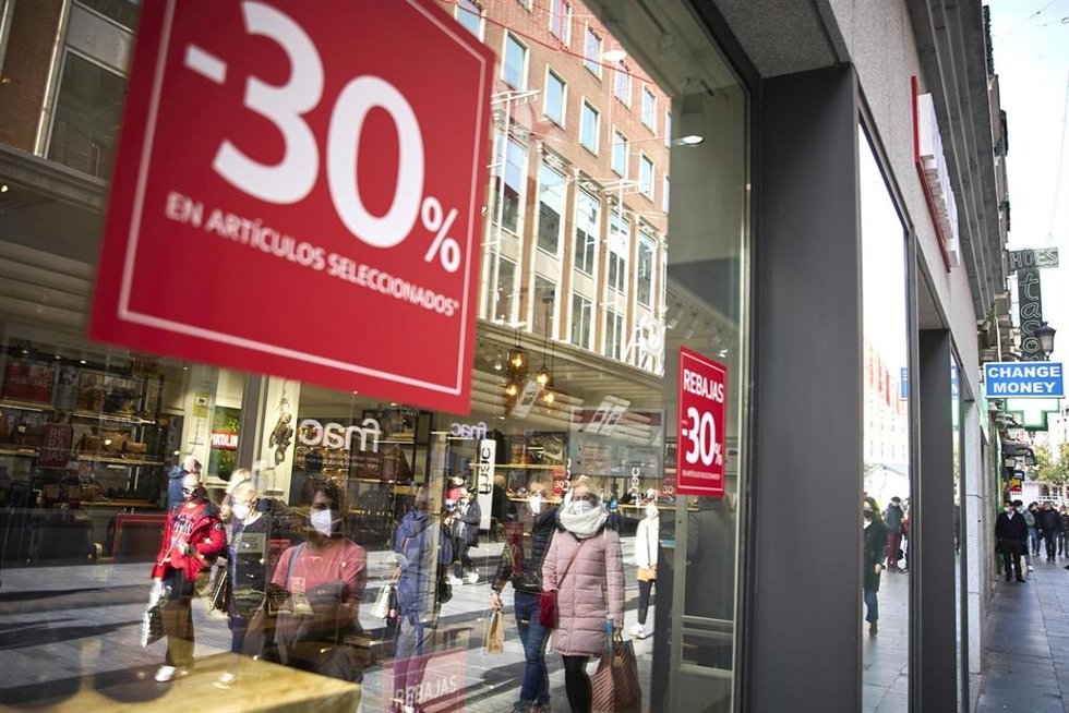 Archivo - Un cartel de rebajas en un escaparate en una calle comercial de Madrid.