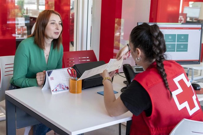 Personal de Cruz Roja asesora a una mujer en materia de empleo.