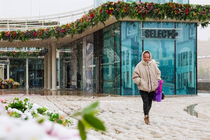 RÚSSIA, MOSCOU - 27 DE ABRIL DE 2026: Uma jovem na rua Pushkinskaya Naberezhnaya durante uma nevasca na primavera