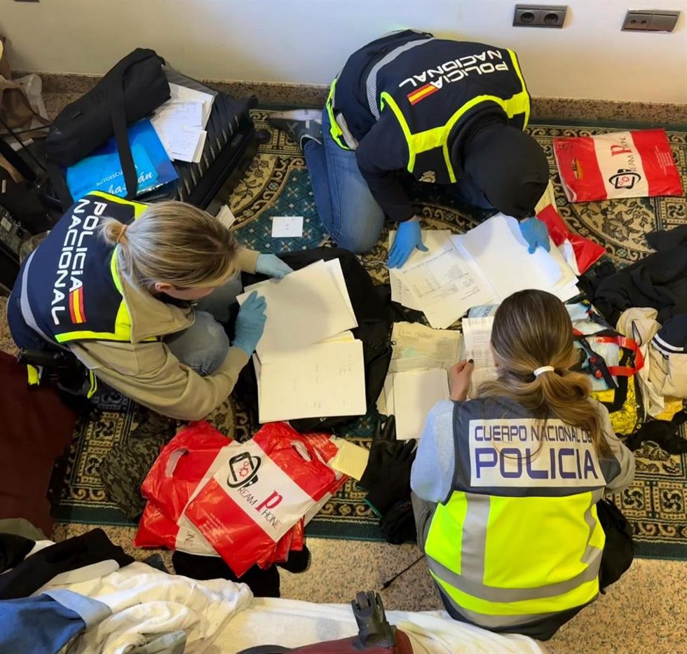 Agentes de la Policía Nacional revisan documentación durante la operación contra una trama de contratos falsos y altas fraudulentas en la Seguridad Social en Roquetas de Mar (Almería).