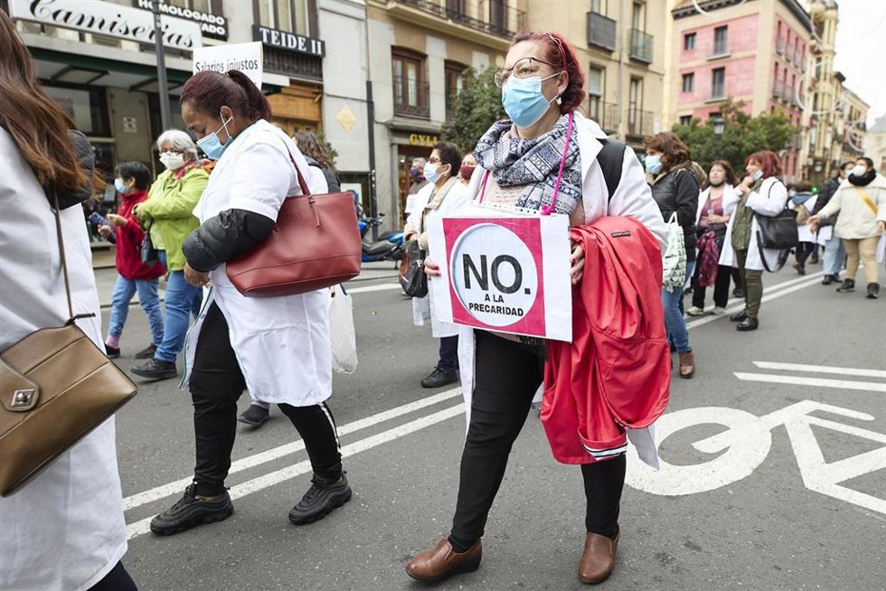 Archivo - Una mujer sostiene una pancarta donde se lee "No a la precariedad", en una manifestación de profesionales sociosanitarias, a 21 de noviembre de 2021, en Madrid (España). 