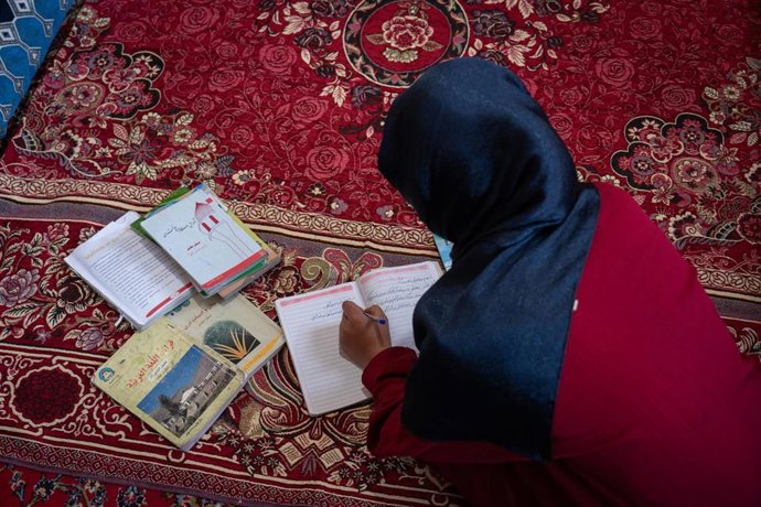 Wahida, una afgana de catorce años, estudiando en su casa tras quedar fuera de la escuela por la prohibición de los talibán a que las niñas reciban educación secundaria y superior en Afganistán