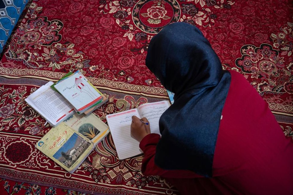 Wahida, una afgana de catorce años, estudiando en su casa tras quedar fuera de la escuela por la prohibición de los talibán a que las niñas reciban educación secundaria y superior en Afganistán
