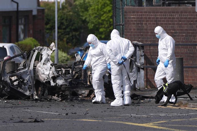 26 April 2026, United Kingdom, Dunmurry: Forensic investigators work at the scene in Dunmurry in Northern Ireland after a car explosion outside a police station. Photo: Niall Carson/PA Wire/dpa