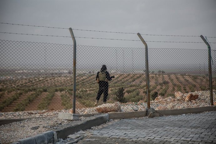Archivo - February 18, 2026, Aleppo Governorate, Syria: A member of the Syrian security forces stands guard outside after hundreds of people were transferred from Al Hol camp in Hasaka Governorate, northeast Syria, to Aq Burhan camp in Aleppo Governorate,