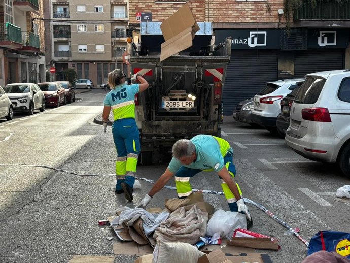 Dos operarios limpian la calle