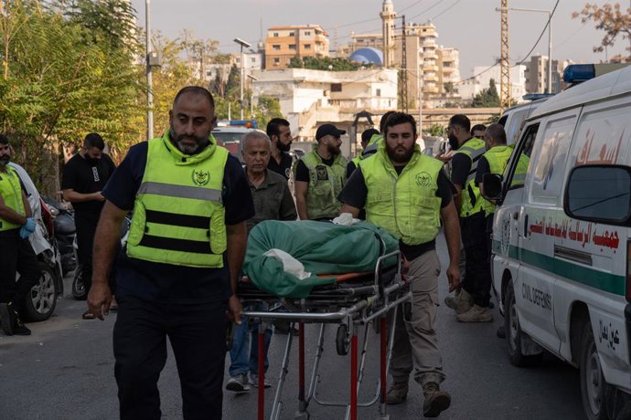 Archivo - Arquivo - 7 de novembro de 2024, Tiro, Líbano: Paramédicos são vistos transportando os corpos em macas ao lado de uma ambulância em Tiro, no Líbano, em 7 de novembro de 2024. Pelo menos 30 pessoas morreram após Israel ter atacado um prédio espec
