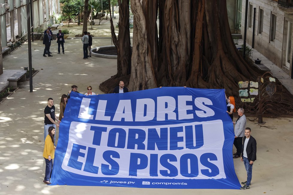 Diputados de Compromís portan la pancarta 'Lladres torneu els pisos'
