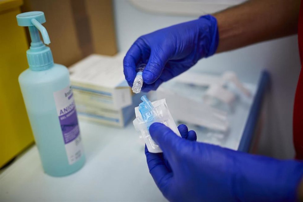 Archivo - Un sanitario de Cruz Roja se prepara para administrar la vacuna contra la gripe.
