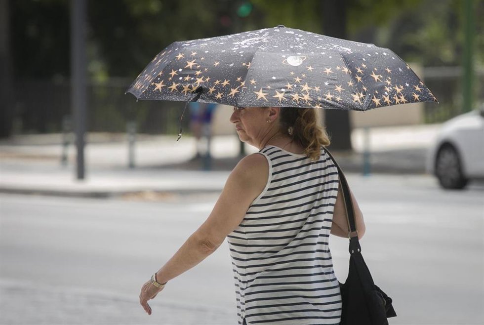 Archivo - Una mujer utiliza un paraguas para protegerse del sol durante la alerta naranja por altas temperaturas. En Sevilla (Andalucía, España), a 23 de junio de 2020.