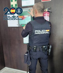 Un agente de la Policía Nacional junto a un desfibrilador