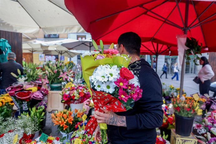 Archivo - Un hombre compra dos ramos de flores en un puesto del Mercado de Flores de Tirso de Molina, a 5 de mayo de 2023, en Madrid (España). Las flores para regalar el Día de la Madre el primer domingo de mayo es una de las tradiciones más populares en 