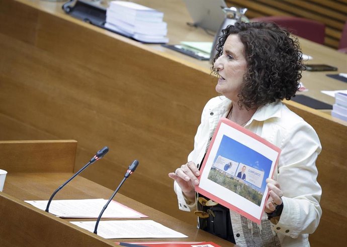 La diputada socialista Mercedes Caballero muestra en Les Corts las vallas instaladas por la Generalitat junto a las del PPCV