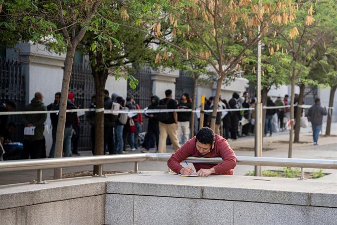 Varias personas hacen cola para conseguir el certificado de vulnerabilidad en una Oficina de Asistencia en Materia de Registro, a 22 de abril de 2026, en Madrid (España). 