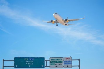 Archivo - Un avión de Vueling sobrevuela sobre la autovía A-4 como imagen de recurso.