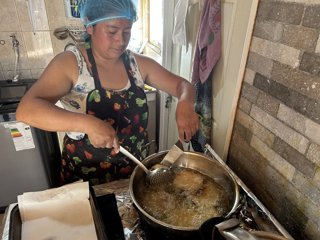 María Cachaña cocinando en su negocio, en Chile