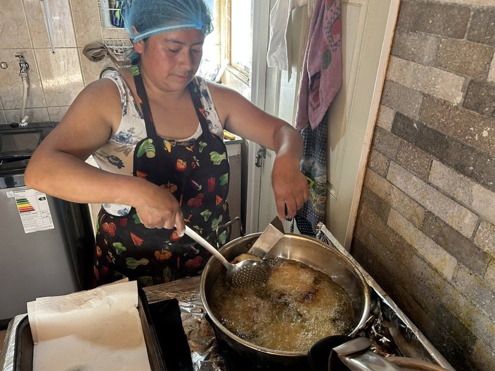 María Cachaña cocinando en su negocio, en Chile