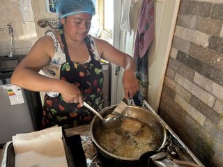 María Cachaña cocinando en su negocio, en Chile