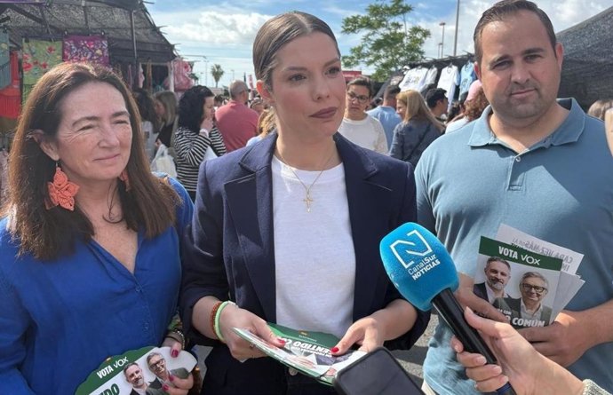 La número dos de Vox por Huelva, María Eiberle, atendiendo a los medios durante un reparto de propaganda electoral en el mercadillo de la capital.