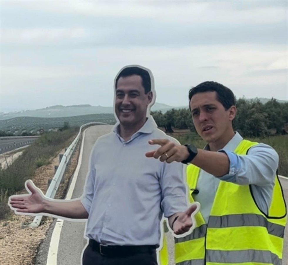 El candidato de Jaén Merece Más (JM+) al Parlamento de Andalucía en las elecciones del 17M Luis García Millán con una figura de cartón del presidente de la Junta y candidato a la reelección, Juanma Moreno, en la A-306.