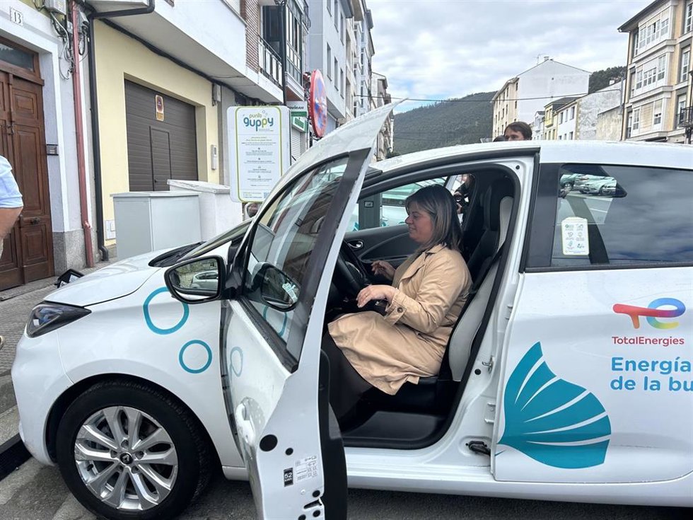 La vicepresidenta del Gobierno de Asturias, Gimena Llamedo, en Vegadeo, en coche eléctrico de un proyecto piloto para mejorar la movilidad en el medio rural.