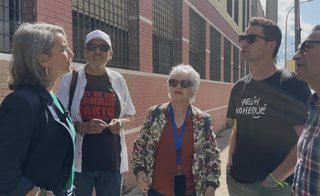Los candidatos de Adelante Andalucía por Sevilla, Begoña Iza y Javi Montes, en la puerta del IES Julio Verne, en el Barrio de Pino Montano.