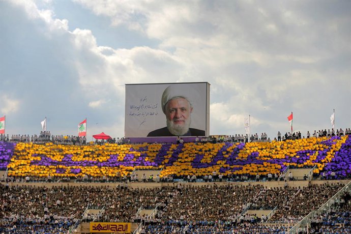 Archivo - Arquivo - 12 de outubro de 2025, Líbano, Beirute: Os escoteiros al-Mahdi do Hezbollah, grupo pró-iraniano, erguem cartões coloridos para formar as palavras “Geração do Mártir” sob uma foto do secretário-geral do Hezbollah, Naim Qassem, durante u
