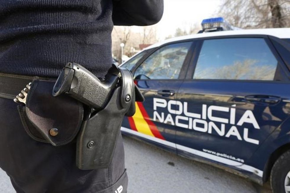 Archivo - Imagen de archivo de un agente y coche patrulla de la Policía Nacional
