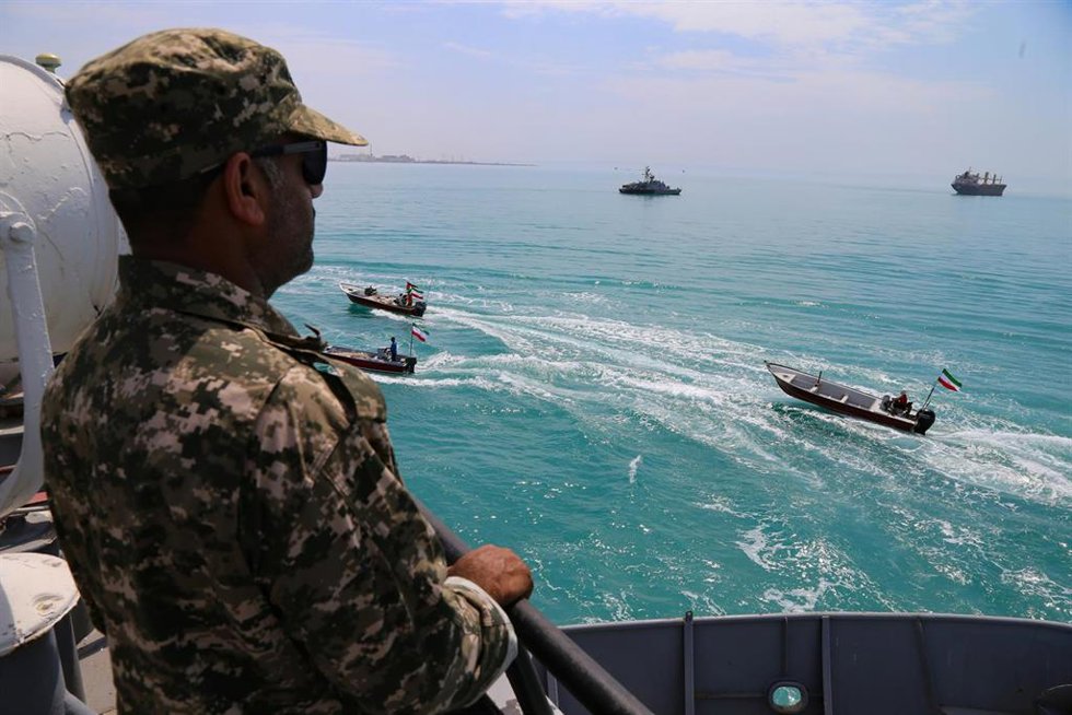 Archivo - Un miembro de la Armada de la Guardia Revolucionaria Islámica vigila mientras varias lanchas rápidas iraníes de la milicia paramilitar Basij navegan por el Golfo Pérsico durante durante un desfile naval