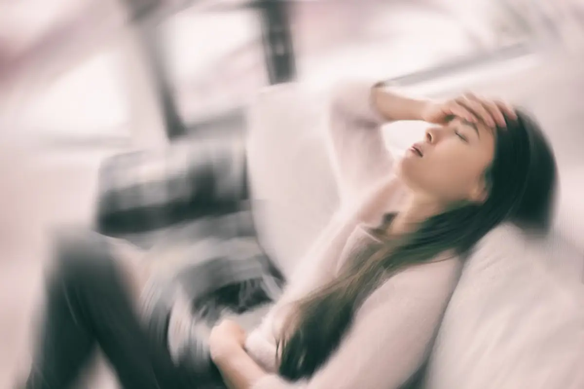 Mujer enferma con dolor de cabeza que siente vértigo leve sosteniendo la cabeza con dolor con fiebre y migraña.