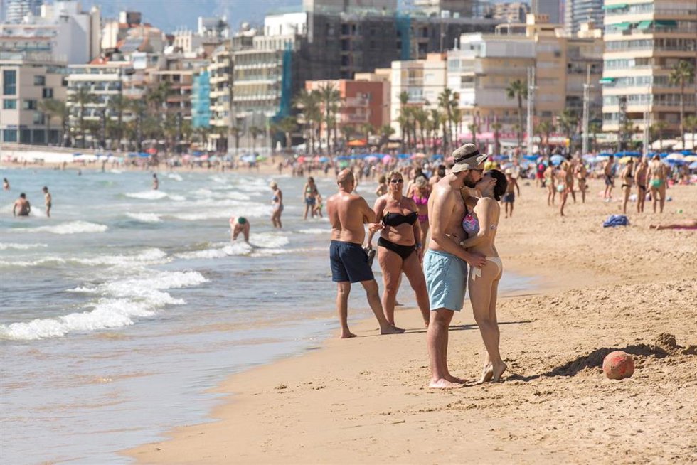 Archivo - Una pareja en bañador se besa en la playa de Poniente, a 11 de marzo de 2023, en Benidorm, Alicante, Comunidad Valenciana (España). Durante este fin de semana, la provincia de Alicante experimenta una subida de temperaturas de entre 8 y 10 grado