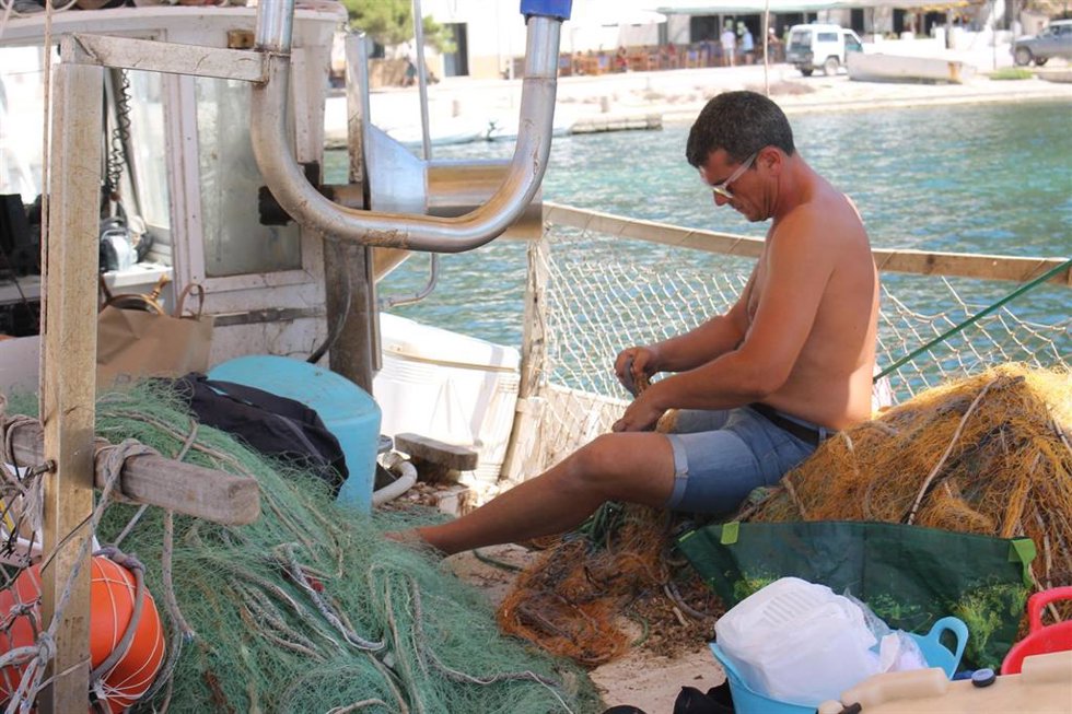 Archivo - Un pescador arregla sus redes, en una foto de archivo.