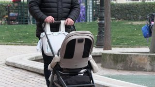 Archivo - Una manos de hombre empujan un carrito de bebé.